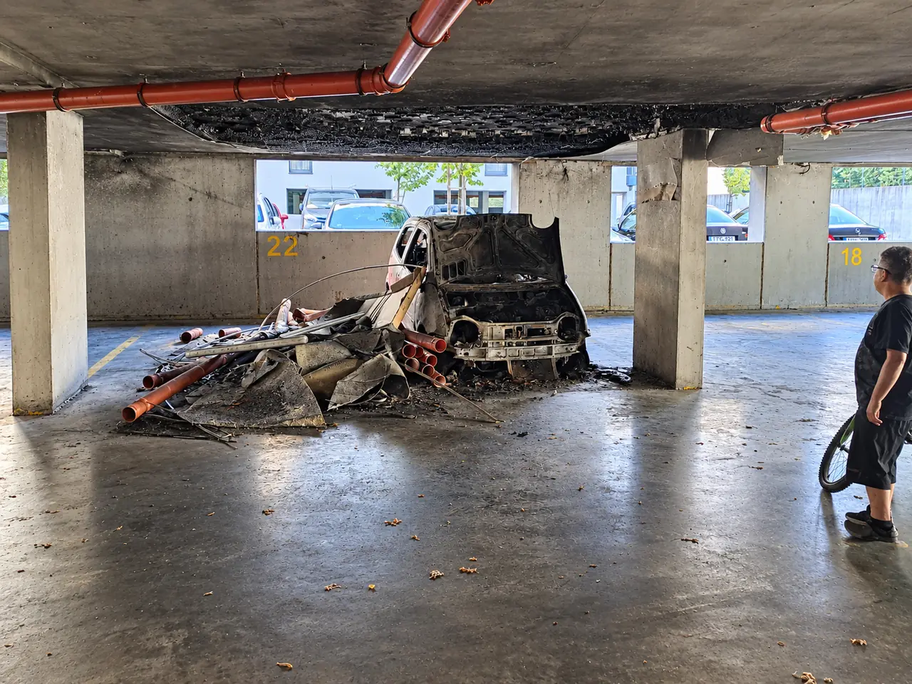 Parkolószint tűzkár után – kiégett autó, korom és törmelék